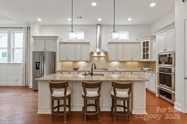 7913 Waverly Walk Ave, Charlotte, NC 28277 - kitchen featuring stainless steel appliances, a sink, a warming drawer, a center island with sink, and wall chimney exhaust hood
