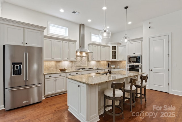 7913 Waverly Walk Ave, Charlotte, NC 28277 - kitchen featuring stainless steel appliances, a sink, wall chimney exhaust hood, tasteful backsplash, and dark wood-style floors