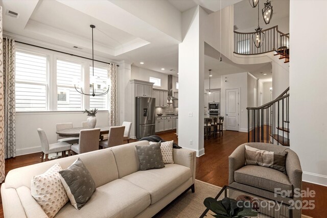 7913 Waverly Walk Ave, Charlotte, NC 28277 - living room featuring a chandelier, stairway, dark wood-type flooring, baseboards, and ornamental molding