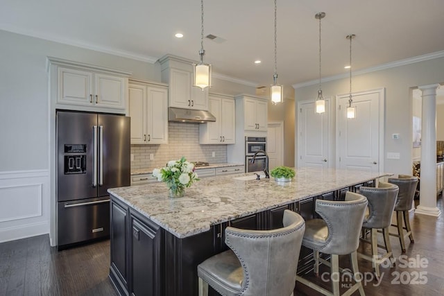 14503 Crest Ct, Charlotte, NC 28278 - kitchen featuring appliances with stainless steel finishes, under cabinet range hood, a spacious island, backsplash, and crown molding
