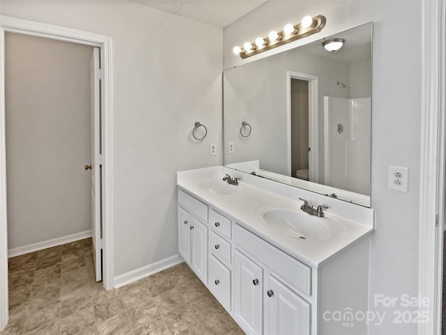 752 Raindrops Rd, Gastonia, NC 28054 - bathroom featuring toilet, double vanity, a shower, and baseboards