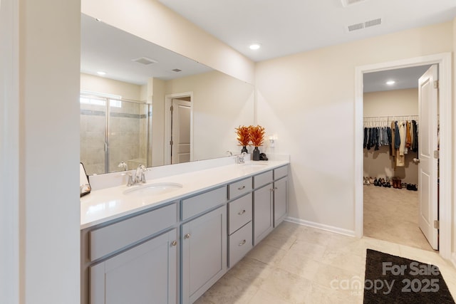 1001 Linn Cv, Waxhaw, NC 28173 - bathroom with a shower stall, a walk in closet, double vanity, baseboards, and tile patterned flooring