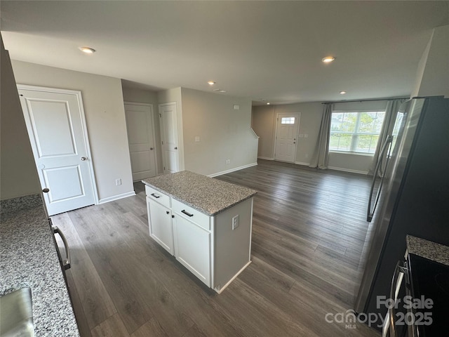 kitchen with recessed lighting, dark wood-style floors, white cabinets, baseboards, and light stone countertops