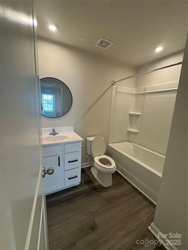 bathroom featuring wood finished floors, vanity, toilet, recessed lighting, and  shower combination
