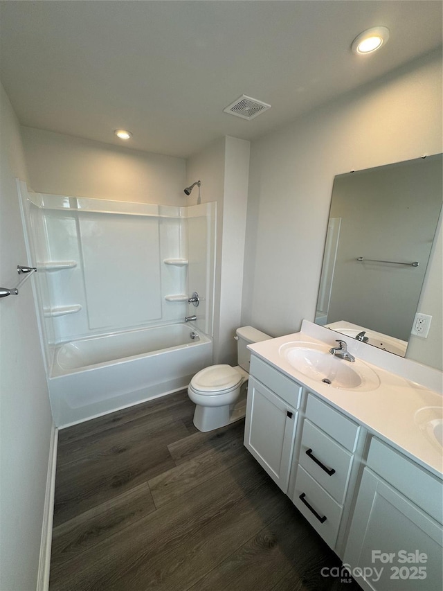 full bathroom with wood finished floors, double vanity, toilet, recessed lighting, and shower / washtub combination