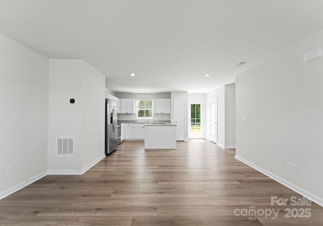 110 Browband St, Troutman, NC 28166 - unfurnished living room with wood finished floors, baseboards, and recessed lighting