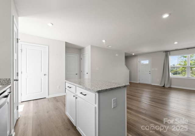 110 Browband St, Troutman, NC 28166 - kitchen with light wood-type flooring, a kitchen island, white cabinetry, baseboards, and recessed lighting