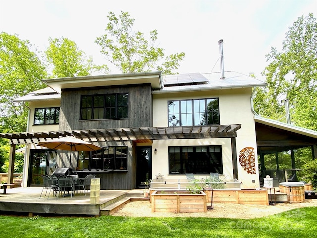 7 Bee Balm Way, Asheville, NC 28804 - rear view of house with a pergola, a deck, roof mounted solar panels, and outdoor dining space