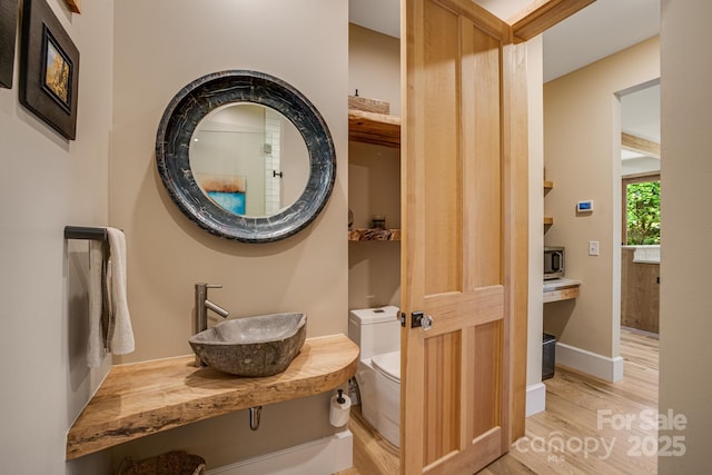 7 Bee Balm Way, Asheville, NC 28804 - bathroom with wood finished floors, a sink, toilet, and baseboards