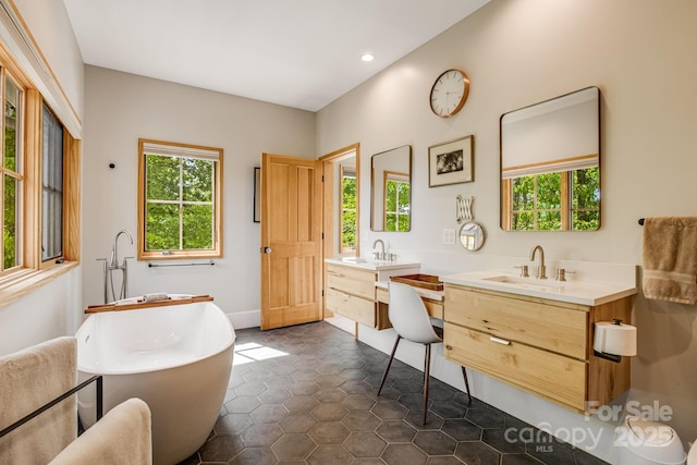 7 Bee Balm Way, Asheville, NC 28804 - bathroom with two vanities, a freestanding tub, recessed lighting, and baseboards