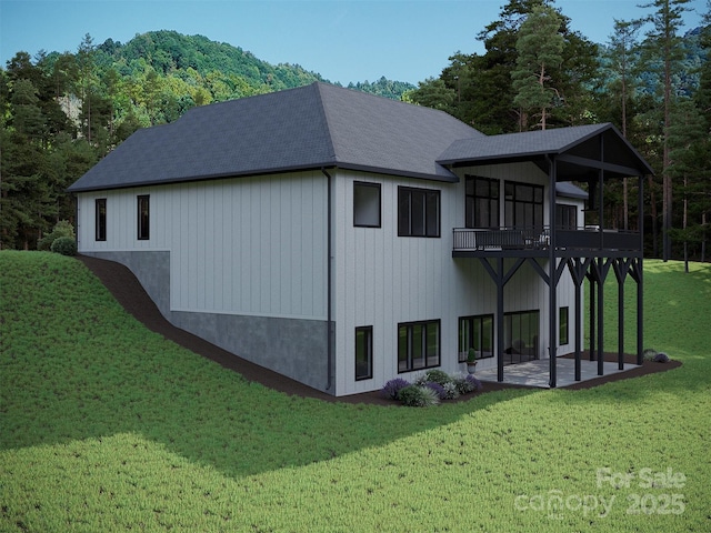 view of side of home with a patio, a lawn, and roof with shingles