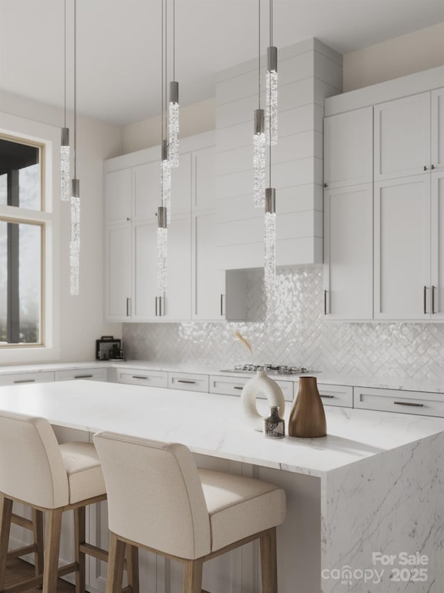 kitchen featuring tasteful backsplash, hanging light fixtures, and white cabinetry