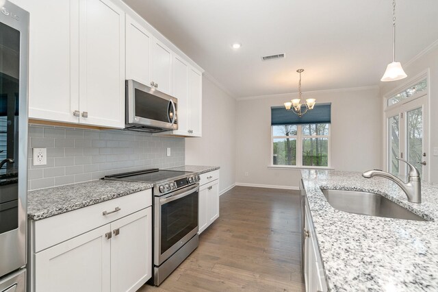 829 River Park Rd, Belmont, NC 28012 - kitchen with stainless steel appliances, a sink, ornamental molding, wood finished floors, and decorative backsplash