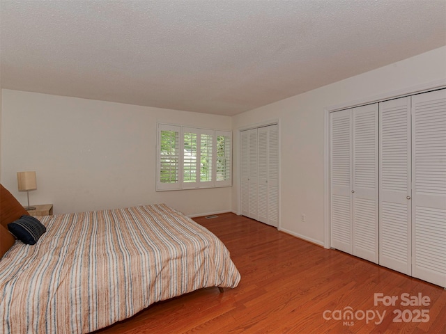 4025 Woodfox Dr, Charlotte, NC 28277 - bedroom featuring two closets, wood finished floors, and baseboards