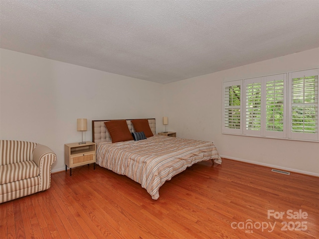 4025 Woodfox Dr, Charlotte, NC 28277 - bedroom with wood finished floors, baseboards, and a textured ceiling