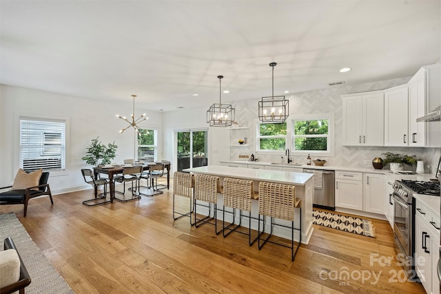 3163 Maury St, Charlotte, NC 28208 - kitchen featuring appliances with stainless steel finishes, a sink, a chandelier, healthy amount of natural light, and recessed lighting