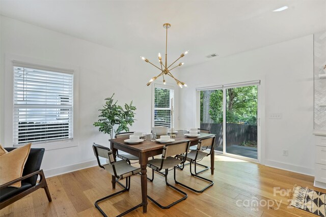 3163 Maury St, Charlotte, NC 28208 - dining area with light wood finished floors, a chandelier, and baseboards
