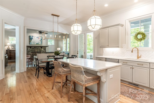 20 E Owl Creek Ln, Fairview, NC 28730 - kitchen featuring a sink, backsplash, a kitchen island, a stone fireplace, and ornamental molding