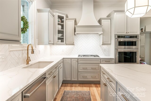 20 E Owl Creek Ln, Fairview, NC 28730 - kitchen with appliances with stainless steel finishes, a sink, custom range hood, ornamental molding, and light wood-style flooring