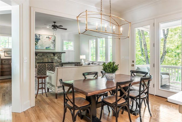 20 E Owl Creek Ln, Fairview, NC 28730 - dining area with light wood-style flooring, ornamental molding, ceiling fan, a chandelier, and a stone fireplace
