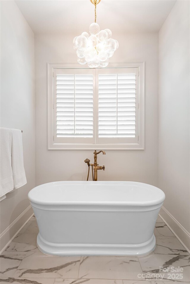 20 E Owl Creek Ln, Fairview, NC 28730 - full bath with marble look tiles, a chandelier, a freestanding bath, and baseboards