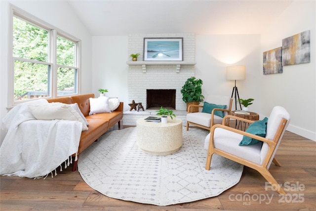 214 Hidden Creek Ln, Burnsville, NC 28714 - living area with vaulted ceiling, wood finished floors, and a brick fireplace