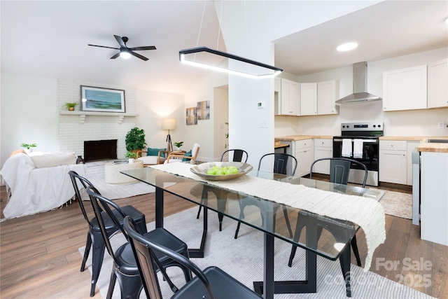 214 Hidden Creek Ln, Burnsville, NC 28714 - dining area featuring wood finished floors, ceiling fan, and a fireplace