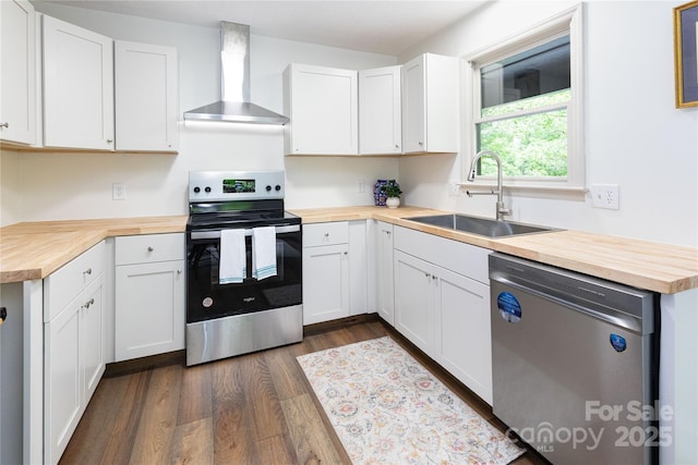 214 Hidden Creek Ln, Burnsville, NC 28714 - kitchen featuring butcher block countertops, stainless steel appliances, wall chimney range hood, a sink, and dark wood-style floors