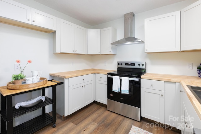 214 Hidden Creek Ln, Burnsville, NC 28714 - kitchen with butcher block countertops, stainless steel range with electric stovetop, wall chimney exhaust hood, and dark wood-style floors