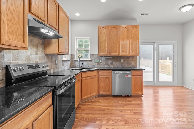 1534 Piney Church Rd, Concord, NC 28025 - kitchen with appliances with stainless steel finishes, under cabinet range hood, a sink, light wood finished floors, and decorative backsplash