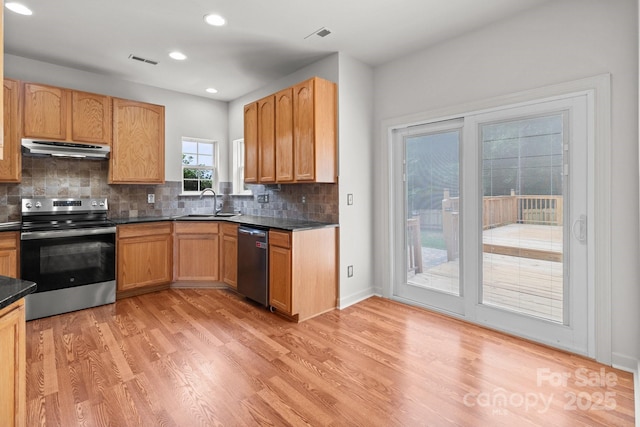 1534 Piney Church Rd, Concord, NC 28025 - kitchen with appliances with stainless steel finishes, under cabinet range hood, dark countertops, light wood finished floors, and decorative backsplash