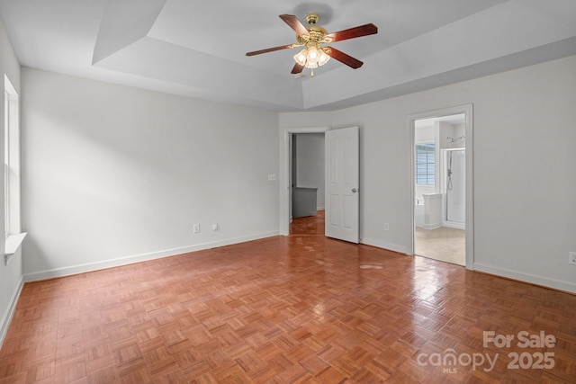 1534 Piney Church Rd, Concord, NC 28025 - unfurnished bedroom featuring a tray ceiling, baseboards, ensuite bathroom, and a ceiling fan