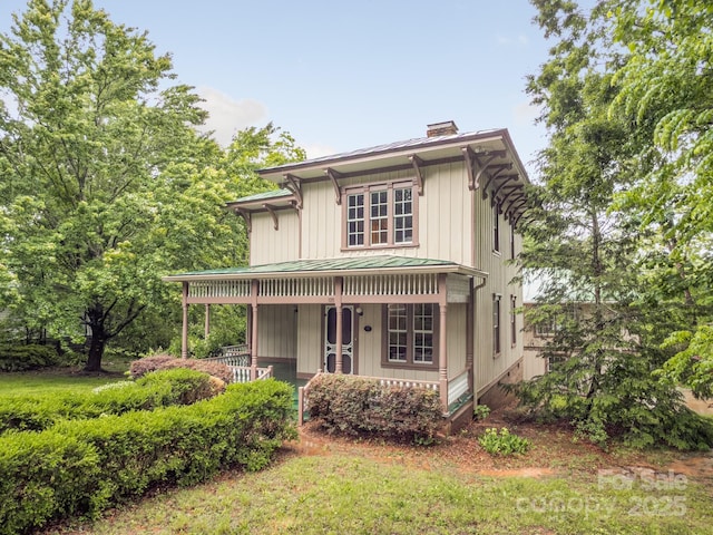 italianate-style house with a porch, a chimney, a standing seam roof, and metal roof