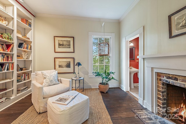 sitting room with a fireplace, ornamental molding, dark wood finished floors, and baseboards