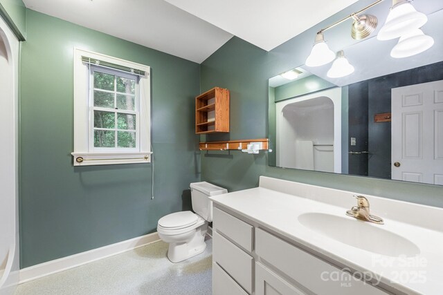bathroom featuring baseboards, vanity, toilet, and speckle patterned floor
