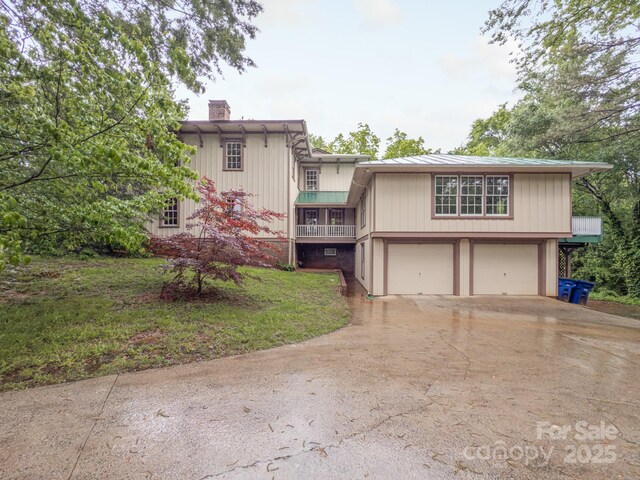 view of front of house with a chimney, driveway, a garage, and a front yard