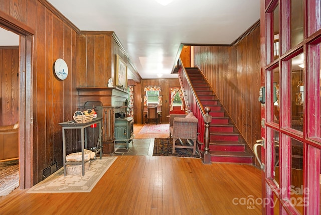 1186 US-70 Hwy, Black Mountain, NC 28711 - entrance foyer featuring a wood stove, wooden walls, hardwood / wood-style flooring, and stairs