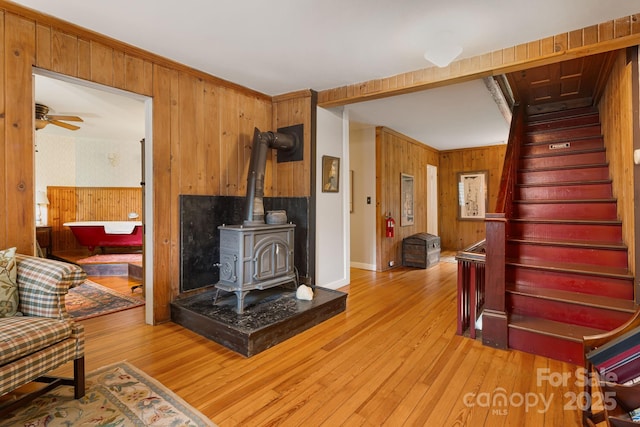 1186 US-70 Hwy, Black Mountain, NC 28711 - living room with wooden walls, stairway, light wood-style floors, wallpapered walls, and a wood stove