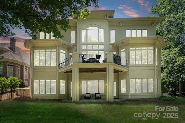 14515 Nolen Ln, Charlotte, NC 28277 - back of house at dusk with a balcony, stucco siding, a sunroom, and a patio