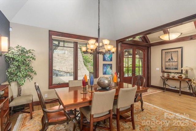2461 Eagles Nest Rd, Waynesville, NC 28786 - dining space with light wood finished floors, a chandelier, plenty of natural light, baseboards, and lofted ceiling