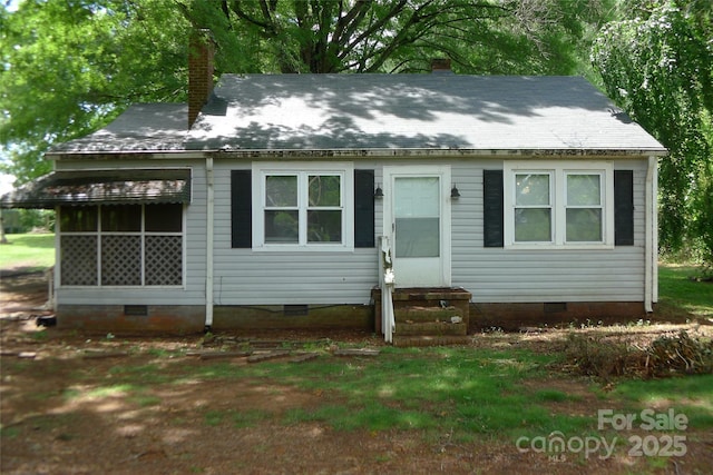 view of front facade featuring crawl space, entry steps, and a chimney