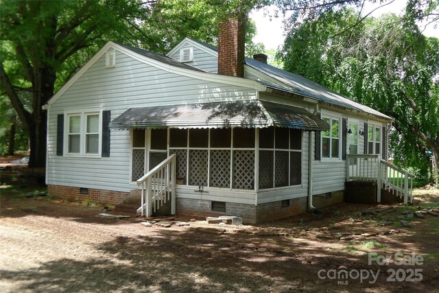rear view of house featuring crawl space and a chimney