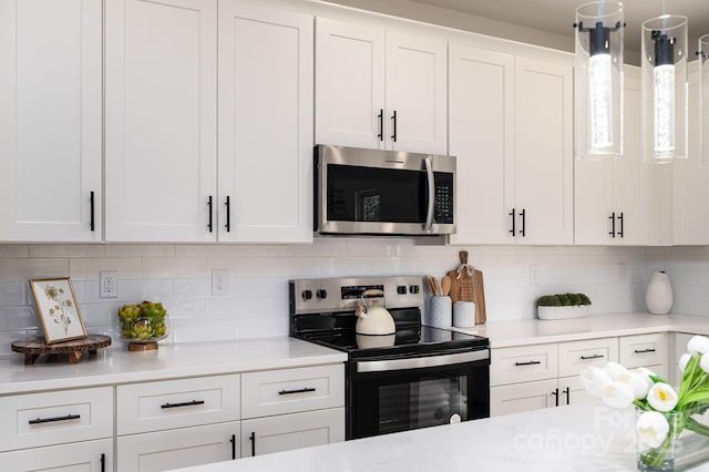 207 9th Ct NE, Conover, NC 28613 - kitchen with stainless steel microwave, electric range, white cabinetry, tasteful backsplash, and hanging light fixtures