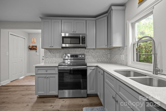 5371 Davidson Rd, Davidson, NC 28036 - kitchen featuring appliances with stainless steel finishes, gray cabinetry, a sink, and backsplash