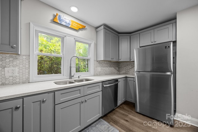 5371 Davidson Rd, Davidson, NC 28036 - kitchen featuring appliances with stainless steel finishes, gray cabinets, a sink, dark wood finished floors, and tasteful backsplash