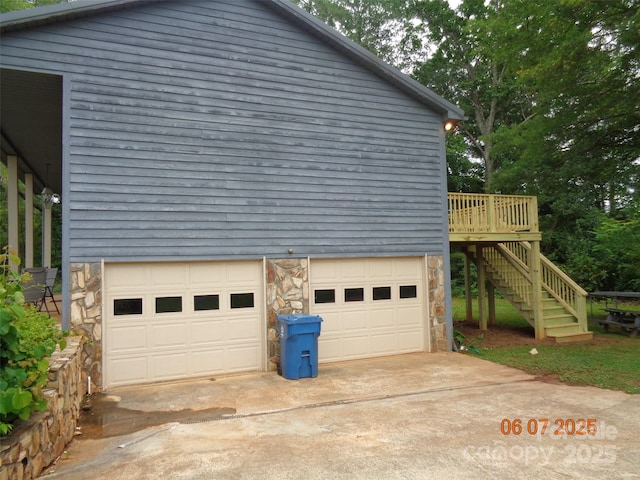 1203 Dudley Shoals Rd, Granite Falls, NC 28630 - view of home's exterior featuring stone siding, concrete driveway, an attached garage, and stairs
