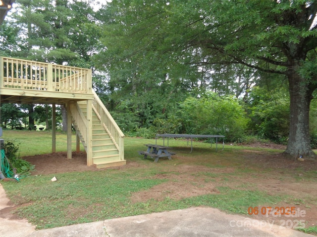 1203 Dudley Shoals Rd, Granite Falls, NC 28630 - view of grassy yard with a trampoline, stairs, a wooden deck, and view of wooded area