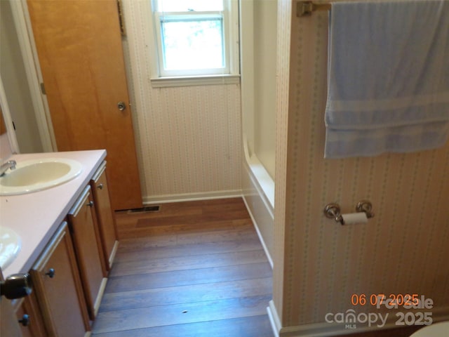 1203 Dudley Shoals Rd, Granite Falls, NC 28630 - full bathroom featuring hardwood / wood-style floors, double vanity, baseboards, shower / washtub combination, and wallpapered walls