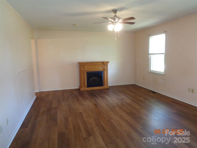 1203 Dudley Shoals Rd, Granite Falls, NC 28630 - unfurnished living room with dark wood-type flooring, ceiling fan, a fireplace with raised hearth, and baseboards