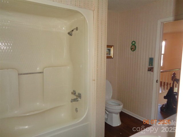 1203 Dudley Shoals Rd, Granite Falls, NC 28630 - bathroom with toilet, baseboards, wood finished floors, wallpapered walls, and bathtub / shower combination